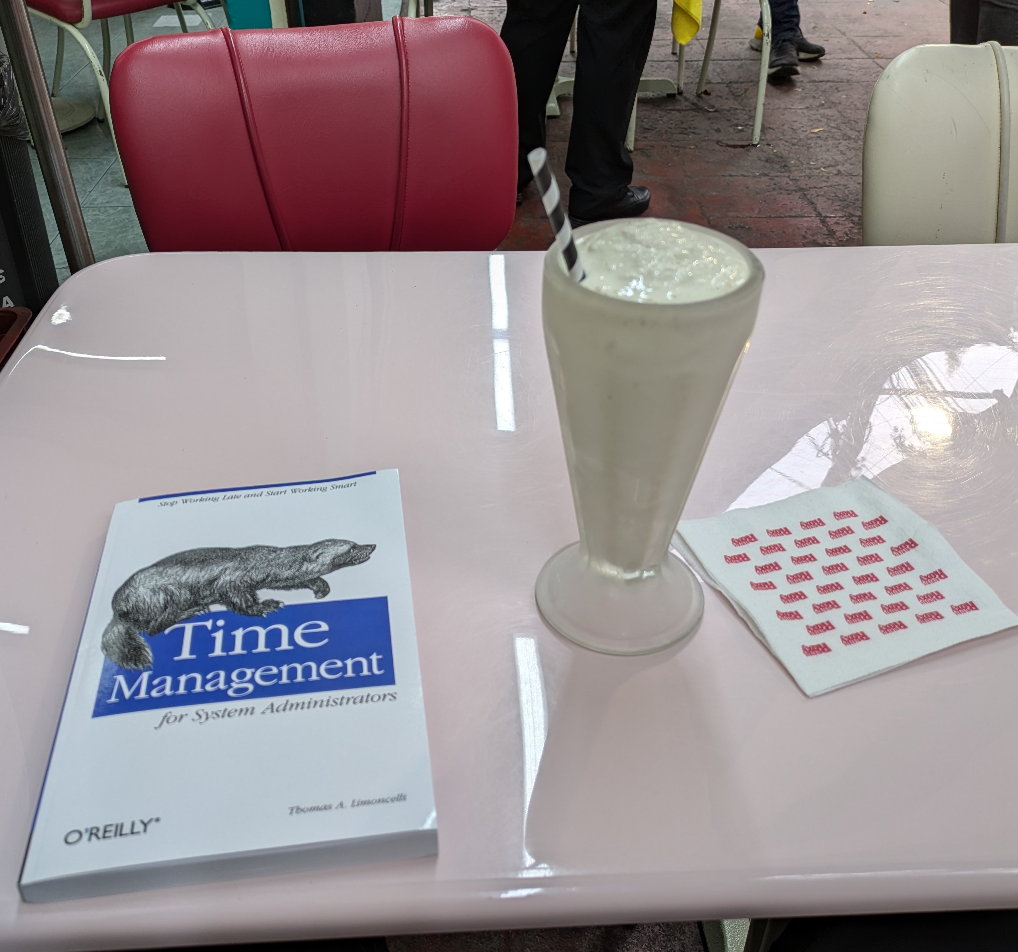 Picture of the book Time Management for System Administrators and a milkshake.